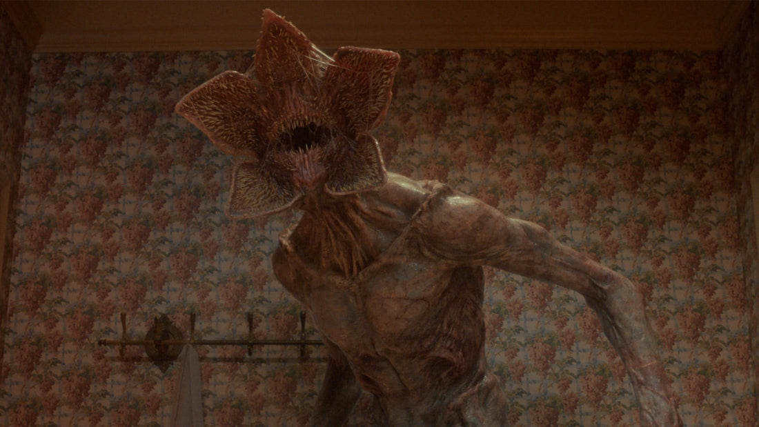 The Demogorgon, mouth open, in a room with floral wallpaper