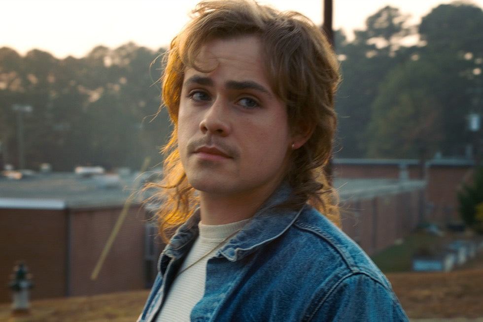 Billy Hargrove, Max's brother, in a denim jacket, looking to the side