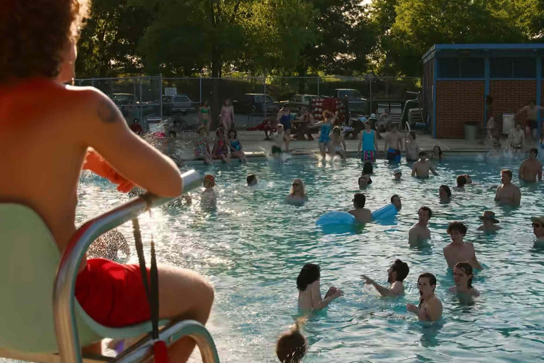 Crowded public pool in summer, with the lifeguard's chair in the foreground.