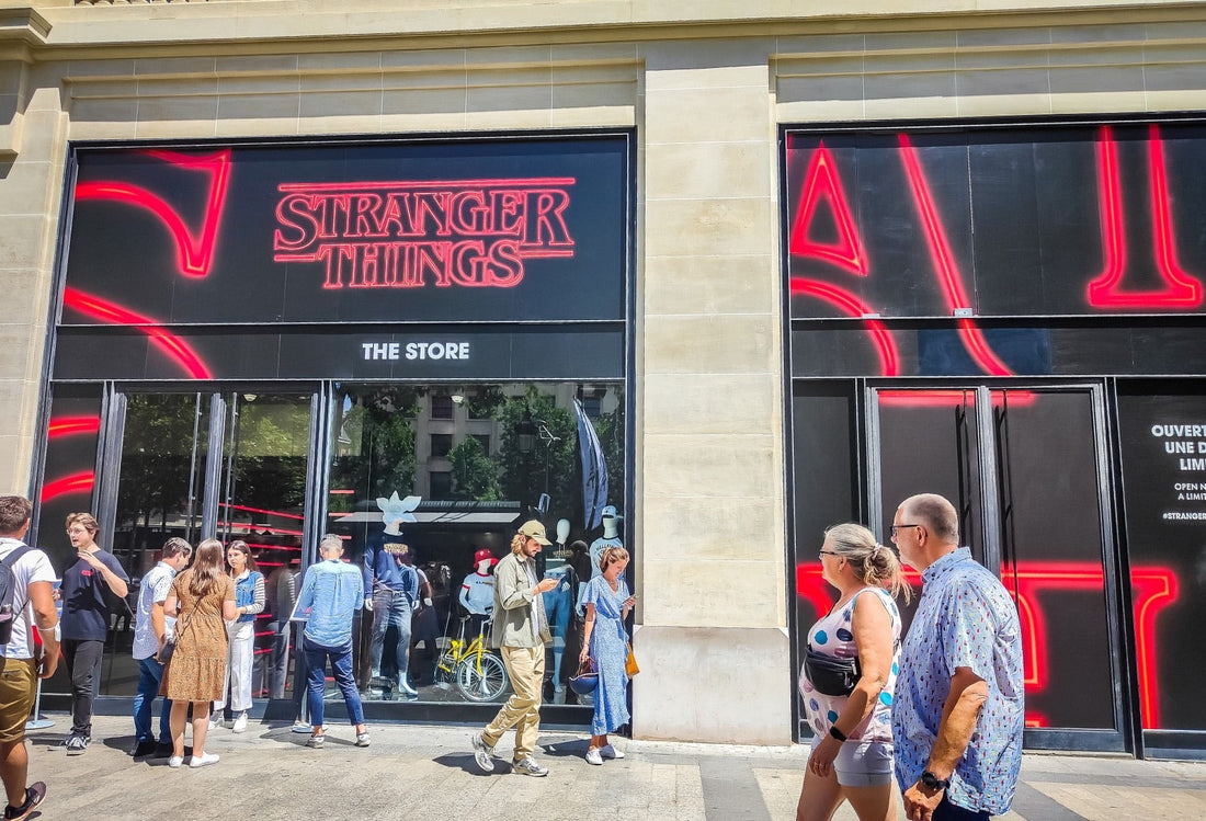 Lit front of a Paris avenue, dark window and red letters