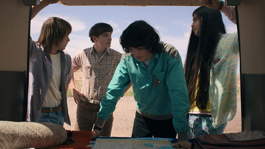 Four teenagers bent over a map, in the back of a van, Stranger Things season 4 episode 5
