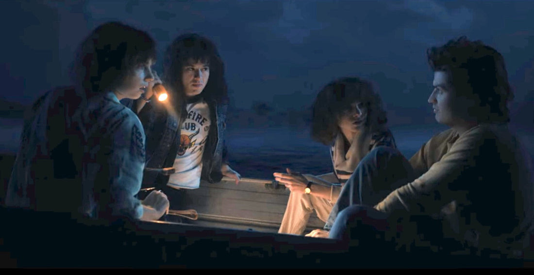 Four teenagers in a boat at night, a lamp in hand, Stranger Things season 4 episode 6