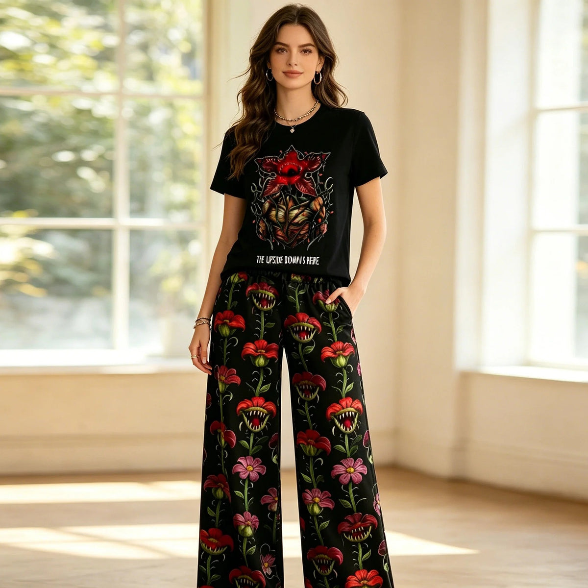 Woman wearing the Stranger Things pajamas with black Demogorgon T-shirt and wide floral pants
