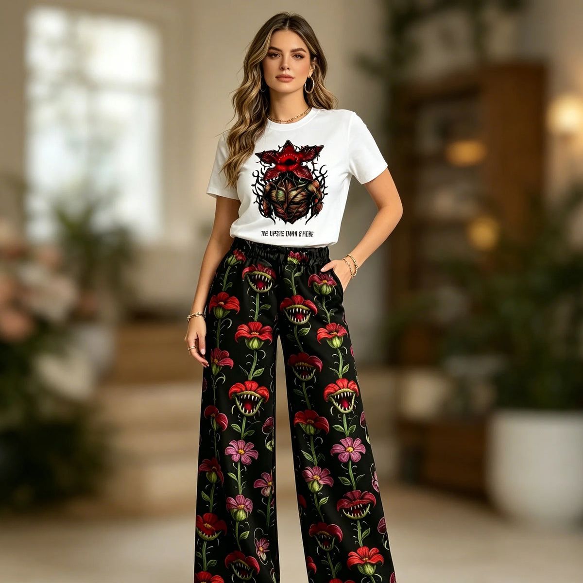 Woman wearing the Stranger Things pajamas with white Demogorgon T-shirt and wide floral pants